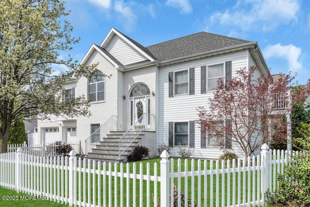 split foyer home with a fenced front yard, an attached garage, and a front yard