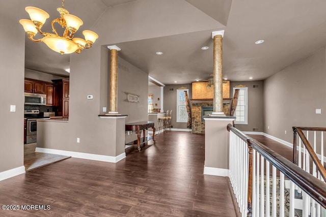 hall featuring decorative columns, recessed lighting, wood finished floors, and a chandelier