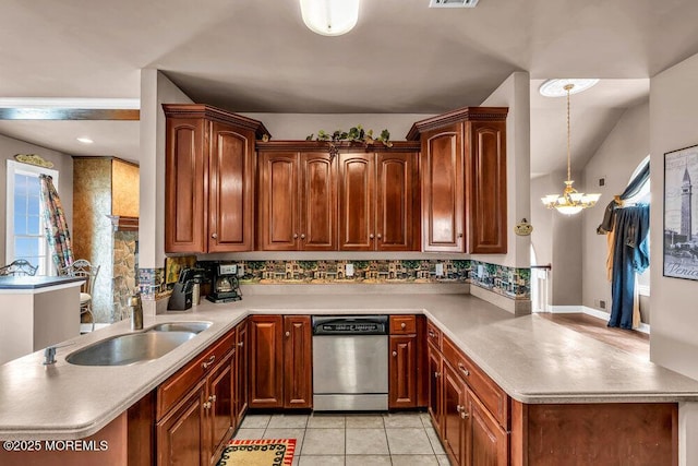 kitchen featuring a notable chandelier, a sink, dishwasher, light countertops, and a peninsula