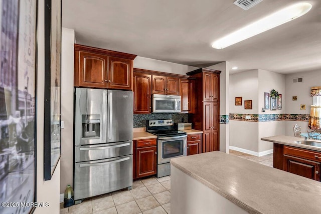 kitchen with visible vents, appliances with stainless steel finishes, light tile patterned floors, and backsplash