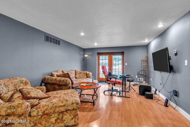 living room featuring recessed lighting, baseboards, visible vents, and wood finished floors