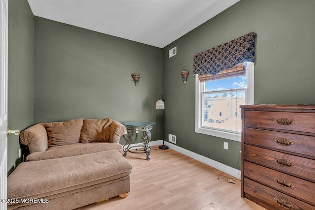 sitting room featuring visible vents, light wood finished floors, and baseboards