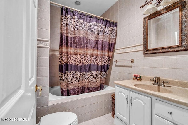full bathroom with vanity, toilet, tile patterned floors, tiled shower / bath, and tile walls