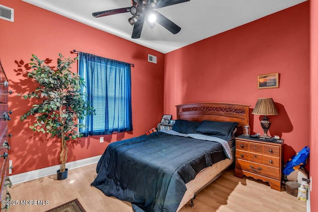 bedroom featuring a ceiling fan, wood finished floors, and visible vents