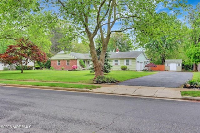 159 Koster Dr, Freehold, NJ 07728 - view of front facade featuring asphalt driveway, a storage unit, a front yard, and an outbuilding