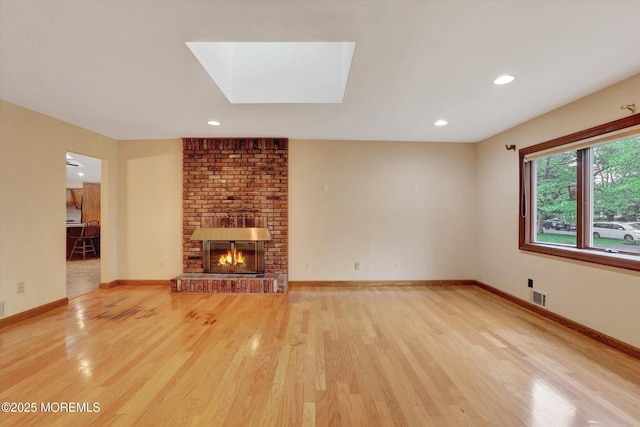 159 Koster Dr, Freehold, NJ 07728 - unfurnished living room featuring light wood finished floors, a fireplace, baseboards, a skylight, and recessed lighting