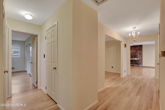159 Koster Dr, Freehold, NJ 07728 - corridor with a chandelier, light wood-style floors, and baseboards