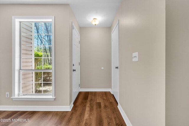 doorway to outside with wood finished floors and baseboards