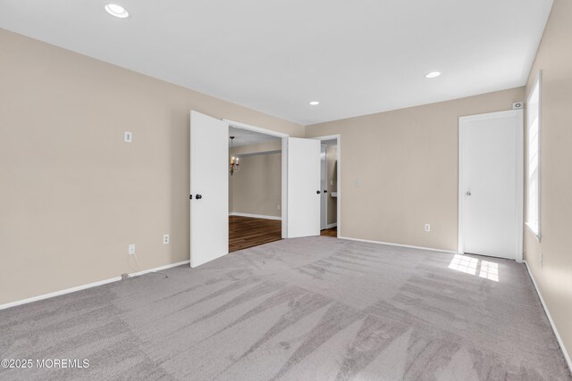 unfurnished bedroom with recessed lighting, carpet, a spacious closet, and baseboards