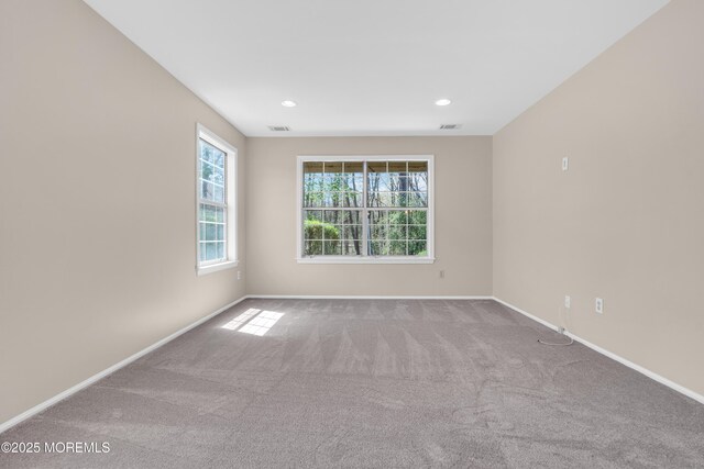 carpeted empty room featuring recessed lighting, visible vents, and baseboards