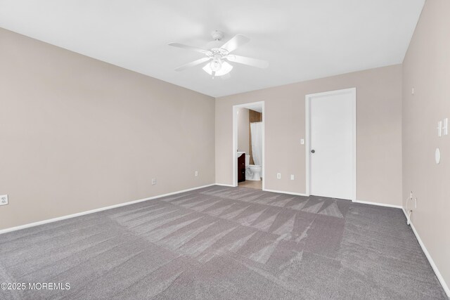 interior space featuring carpet, ensuite bath, baseboards, and ceiling fan