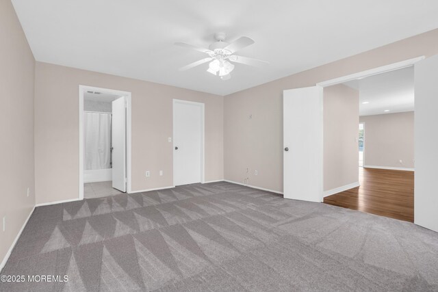 unfurnished bedroom with ceiling fan, carpet floors, and baseboards