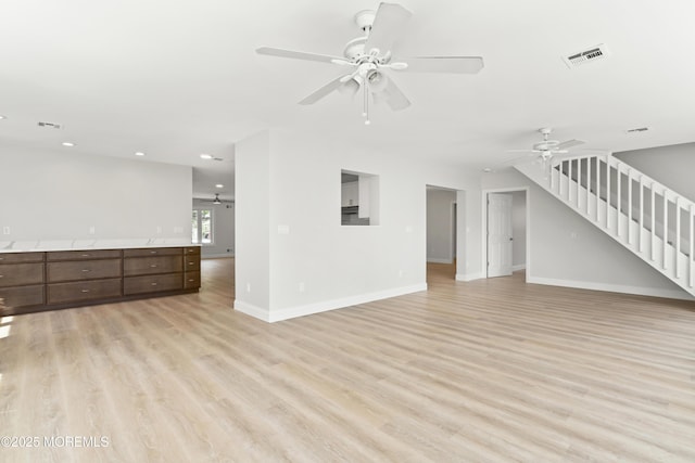 unfurnished living room with recessed lighting, stairway, light wood-style floors, ceiling fan, and baseboards