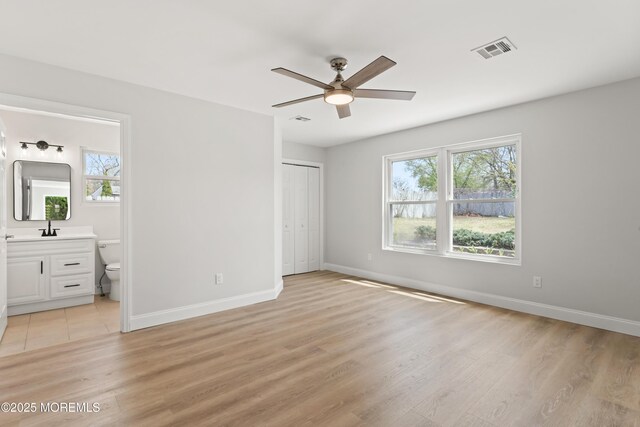 unfurnished bedroom with light wood finished floors, visible vents, and baseboards