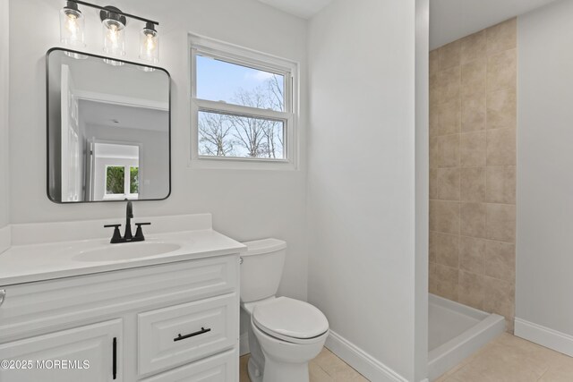 bathroom with tile patterned floors, vanity, toilet, and a shower stall
