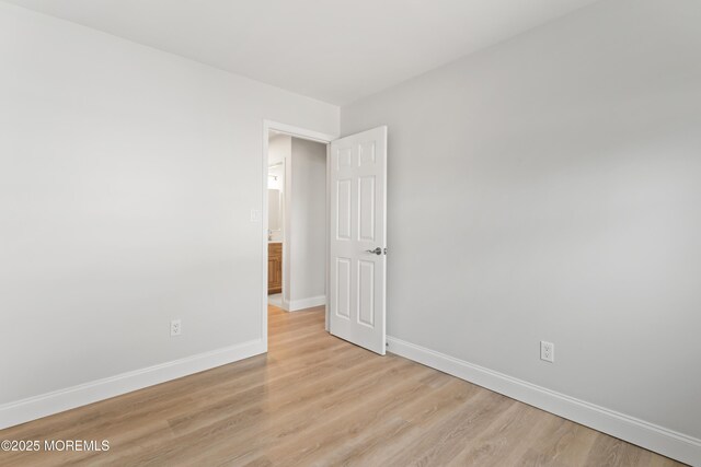 spare room featuring light wood-style floors and baseboards