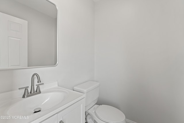 half bathroom featuring toilet and vanity
