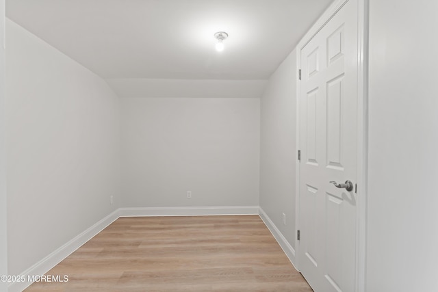 spare room with baseboards and light wood-type flooring