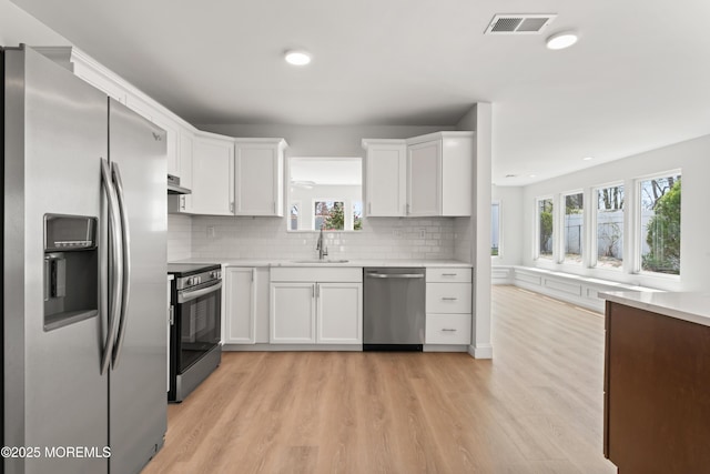 kitchen with stainless steel appliances, light countertops, and a sink