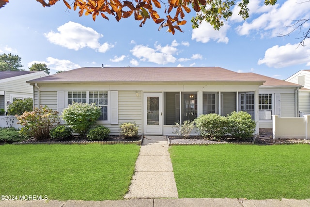 view of front of home with a sunroom and a front yard