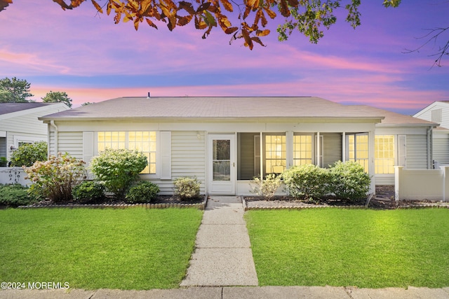 view of front facade featuring a sunroom and a front yard