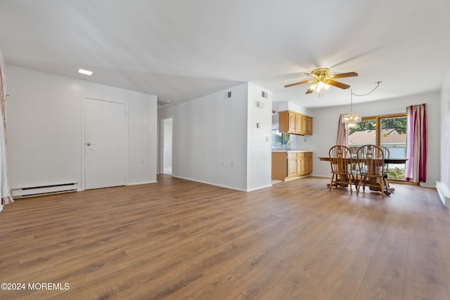 living area with baseboards, visible vents, ceiling fan with notable chandelier, dark wood-type flooring, and a baseboard radiator