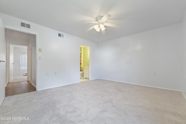 spare room with attic access, visible vents, carpet floors, and ceiling fan