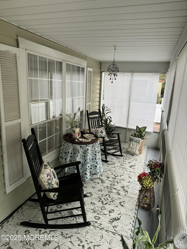 sunroom featuring a chandelier