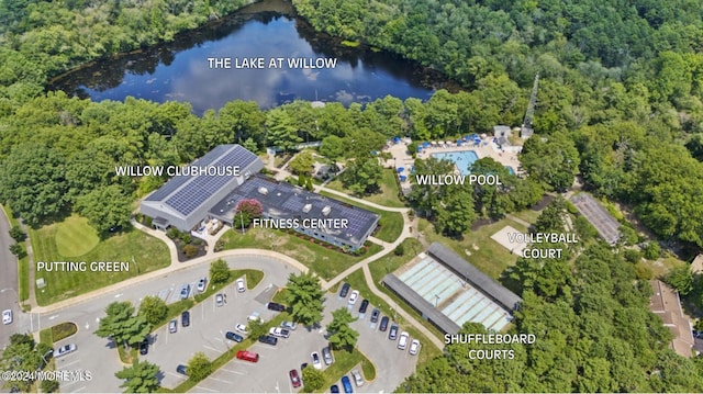 drone / aerial view with a forest view and a water view