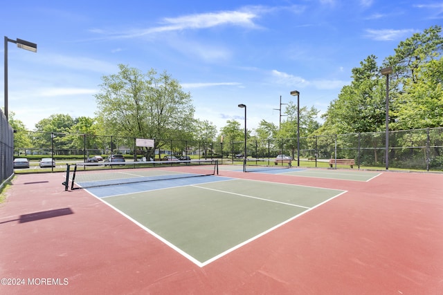 view of tennis court with fence and community basketball court