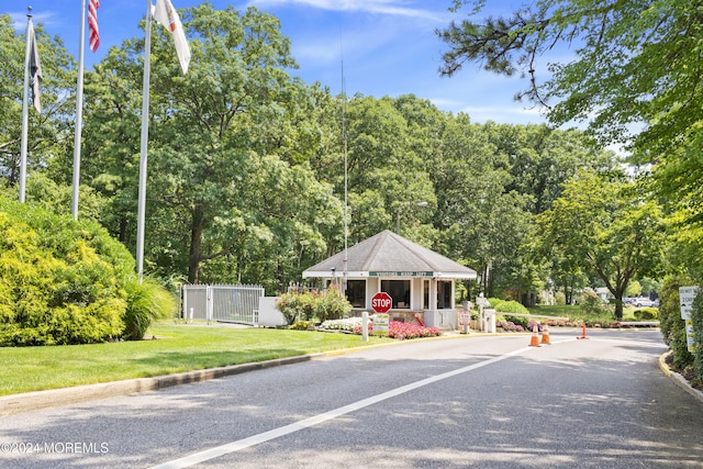 view of street with traffic signs, curbs, and a gate