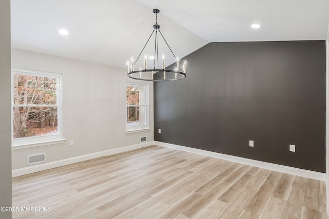 unfurnished dining area with baseboards, visible vents, an inviting chandelier, and light wood-style floors