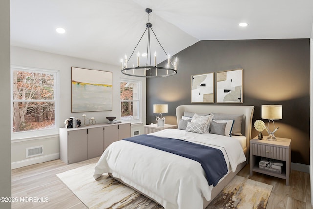 bedroom with visible vents, baseboards, a notable chandelier, lofted ceiling, and light wood-style flooring