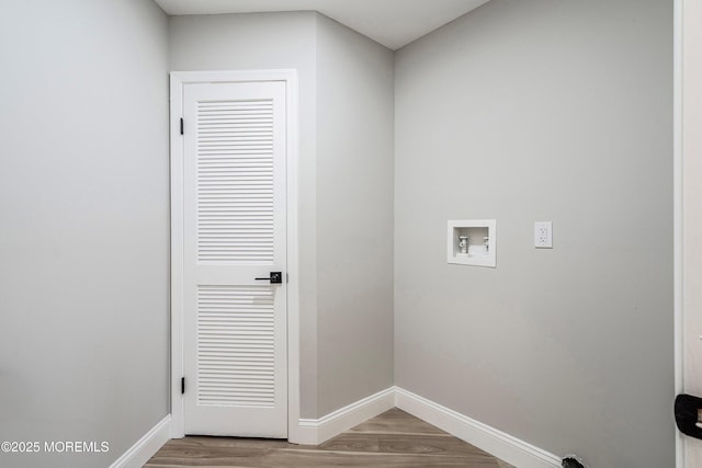 clothes washing area with baseboards, laundry area, washer hookup, and wood finished floors