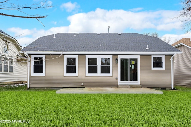 back of property featuring a patio, a shingled roof, and a yard