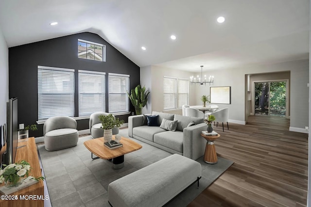 living room featuring wood finished floors, lofted ceiling, a chandelier, and a healthy amount of sunlight