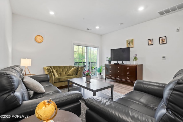 living room with visible vents, recessed lighting, and wood finished floors