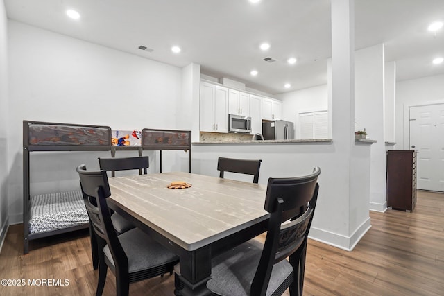 dining area featuring baseboards, recessed lighting, wood finished floors, and visible vents
