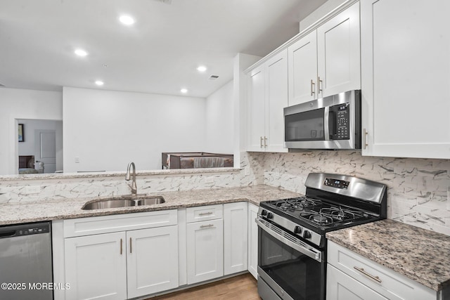 kitchen featuring a sink, white cabinetry, tasteful backsplash, and stainless steel appliances