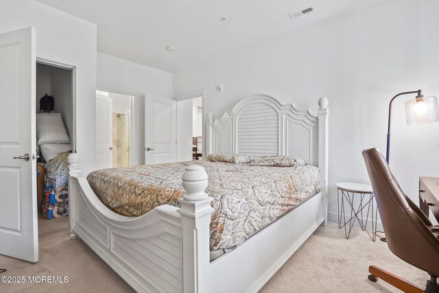 bedroom featuring light colored carpet, baseboards, ensuite bath, and visible vents