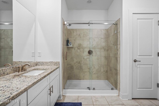 bathroom with a shower stall, tile patterned flooring, and vanity