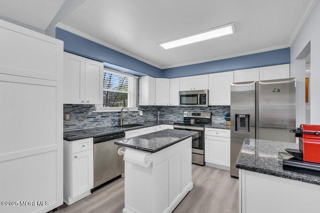 kitchen featuring appliances with stainless steel finishes, decorative backsplash, ornamental molding, and a sink