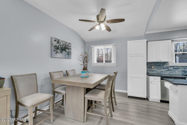 dining space with ceiling fan, plenty of natural light, light wood-style flooring, and vaulted ceiling