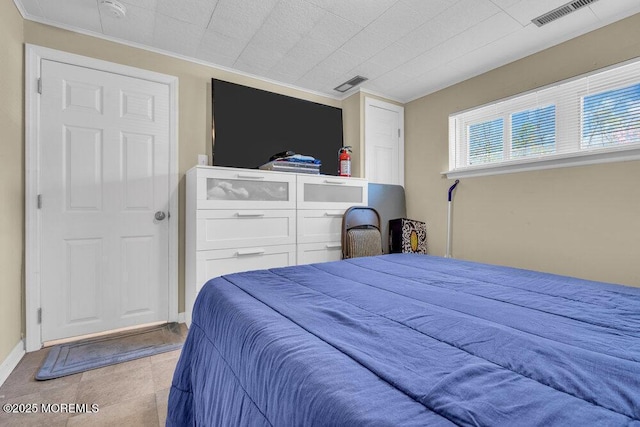 bedroom featuring baseboards, visible vents, and ornamental molding