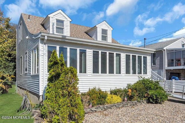 view of property exterior featuring a shingled roof