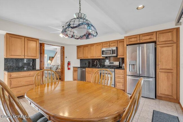 kitchen with decorative backsplash, light tile patterned floors, dark countertops, and stainless steel appliances