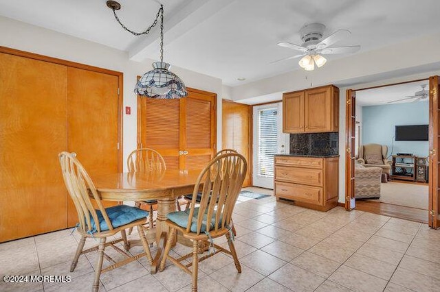 dining space with a ceiling fan and light tile patterned flooring