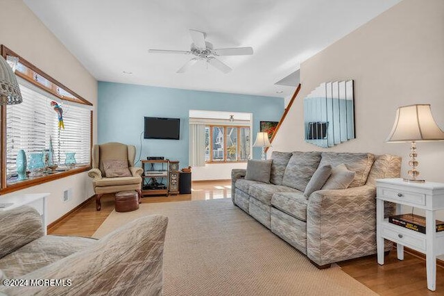 living room featuring a ceiling fan and wood finished floors