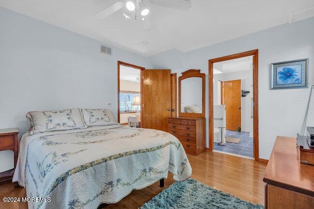 bedroom with visible vents, a ceiling fan, wood finished floors, and vaulted ceiling