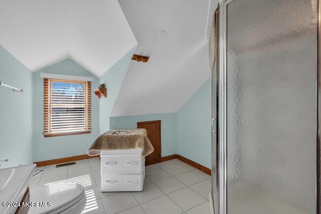 interior space with baseboards, vaulted ceiling, light tile patterned flooring, and visible vents